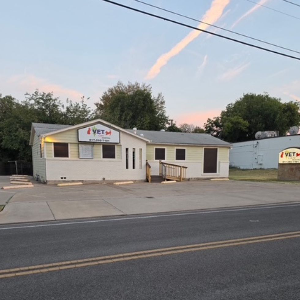 Single-story building with multiple gray doors and yellow awnings Single-story building with multiple gray doors and yellow awnings